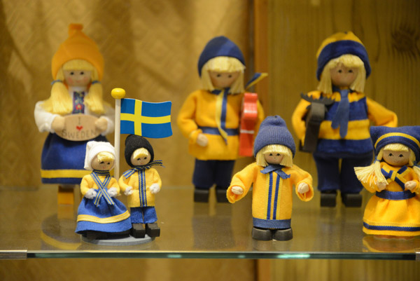 Figurines in the colors of Sweden wearing winter coats and hats