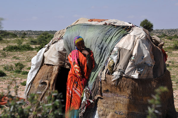Somali woman in front of her small hut