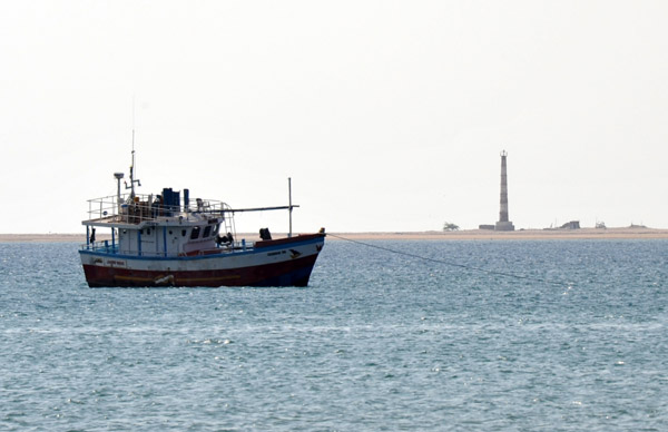 A small fishing boat with Berbera's lighthouse