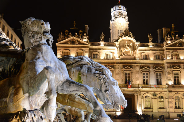 Detail of the Bartholdi Fountain at night with Lyon City Hall
