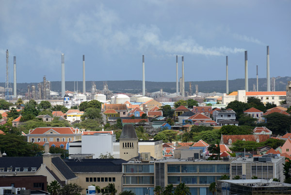 Industrial smokestacks of the giant oil refinery at Curaao lie just beyond the quaint Dutch faades of old Willemstad