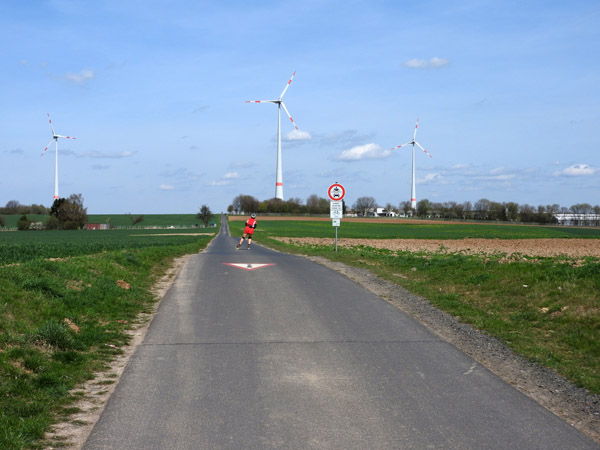 Rollerblader on a narrow lane with Wind Turbines, Schneck 