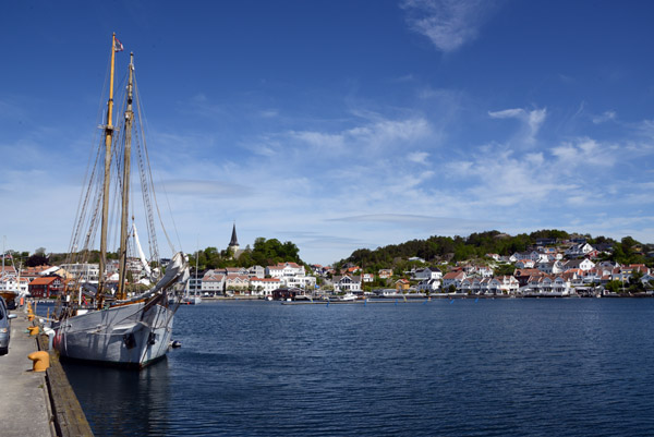Twin-masted sailing vessel tied up along the waterfront of Grimstad