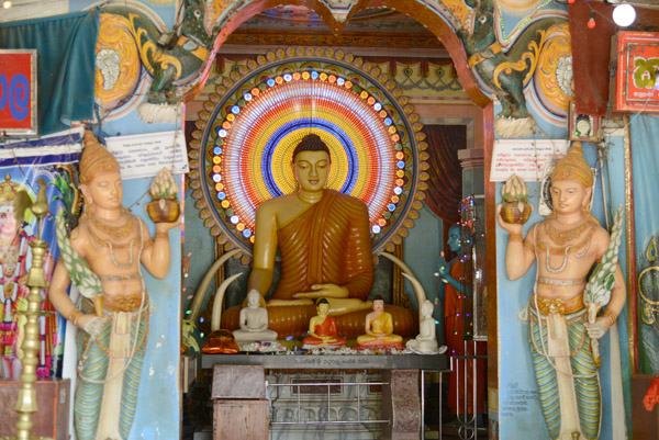 Seated Buddha flanked by 2 figures with offerings, Kataragama