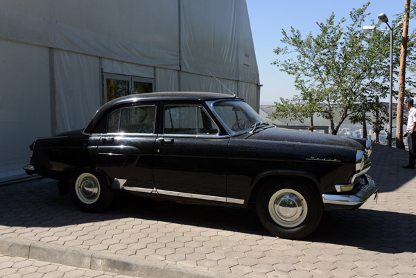 A black Russian Volga sedan in need of a wash