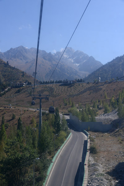 The cable car passing over the road to Shymbulak