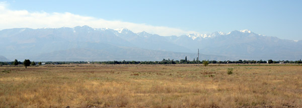 Panorama of the flat plains of Kazakhstan meeting the mountains that form the border with Kyrgystan
