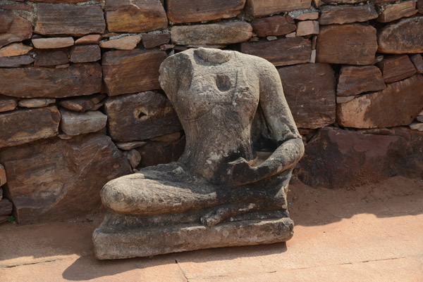 Headless Buddha missing an arm at the Meguti Hill Buddhist Temple