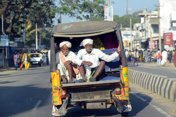 Two mustachioed men in turbans in the back of a three-wheeler, Telangana