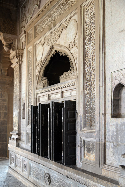 Windows surrounded by ornate calligraphy surround the arcaded veranda