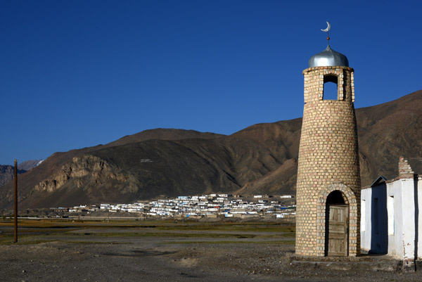 Minaret with the town of Murgab against the hill in the distance