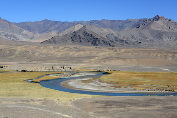 Grasslands on either side along this bend in the Murghab River, lush vegetation for the Pamirs