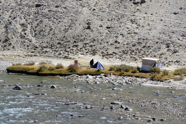 A man camping on the Afghanistan side of the Pamir River near the confluence of the Ali-suu