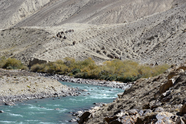 Wider view of the Pamir River with the caravan descending the slope in the background