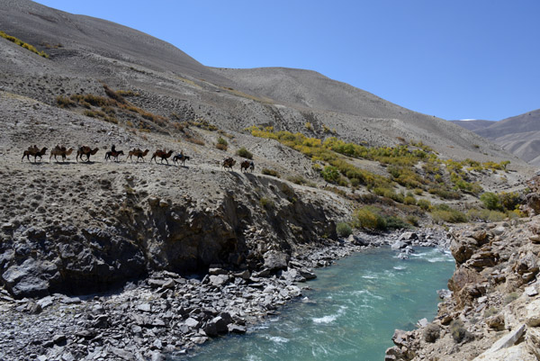The caravan passes by at on the other side of the Pamir River