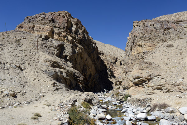 A small stream flowing out of a narrow canyon on the Tajik side of the Pamir Valley
