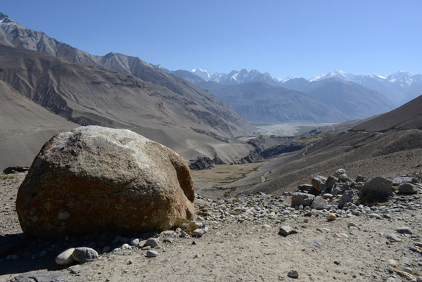 The broad Wakhan Valley comes into sight near a large roadside boulder