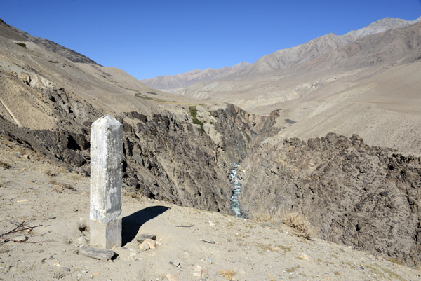 Canyon of the Pamir River with a worn border marker, Tajikistan