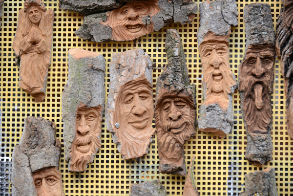 Rustic woodcarvings with faces of old men, Warsaw