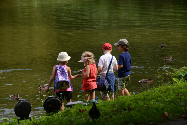 Young Polish children feeding the ducks in Temple of Diana (Temple of the Sibyl), Royal Łazienki Park, Warsaw