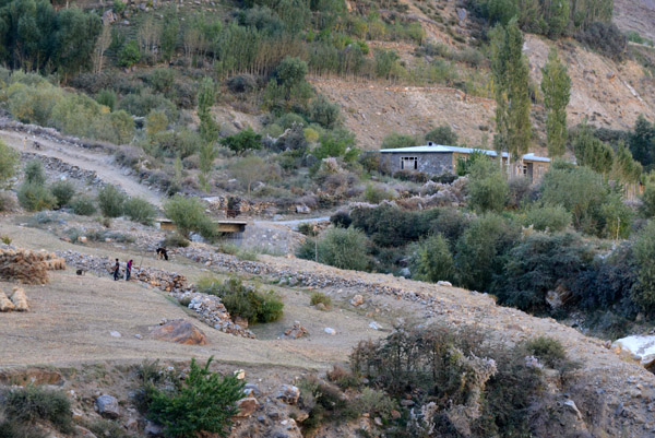 Villagers working in the fields as the harvest waits in bundles