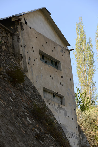 Bullet scared building on the south side of the river, a reminder of the Pamir-Tajik civil war 1992-1997