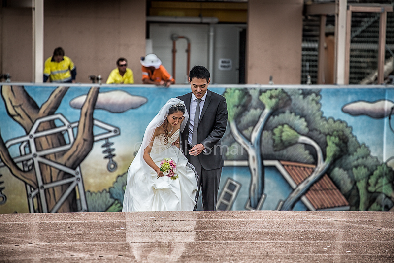 Japanese bride and groom negotiating Opera House steps with construction in background