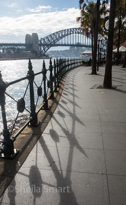 Railings leading down to Sydney Harbour with bridge backdrop