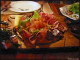 Sampler of variety of meat: wild boar, smoked troute, salmon, venison, cheese and  raw ham.