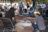 Local man, kneeling in shadows, shoots artist as she discusses her work.   Arraignment next Friday.