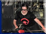 A Young Woman Works Her Glass Creation For The Audience