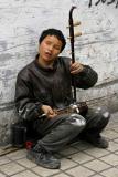 He is blind, loves to play this intrument and sing and does not ask for money.