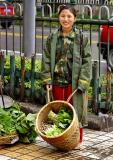 Sidewalk selling of produce and a friendly smile.