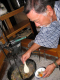 Miso soup from a pot suspended over heat.