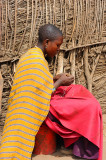 She s making  necklace for sell at the village