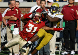 Jackets B-back Dwyer is knocked to the turf by Noles LB Verdell after making a leaping catch
