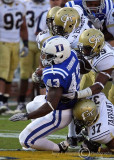 Yellow Jackets defenders pull down blue Devils RB Patrick Kurunwune