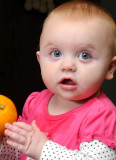 Grace trying to eat an orange