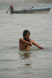 Man Bathing in the Ganges with Small Boat in Background
