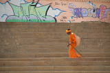 Saddhu Walking on Ghats with Graffiti in Background