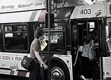 TWO FOLKS GETTING ON A BUS,  AND TWO WINDOWS AND TWO WHEELCHAIR DECALS??