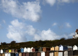 Frinton - beach huts with seaside feel amplified by hotel top right and modern shelter top left