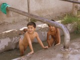 Boys cool off outside the Margilan  silk factory