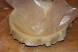 Flip your waxed paper and crust over the pie plate.  Peel paper away,  fold edges under,  and crimp the crust