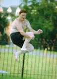 Teen boy jumps in pool