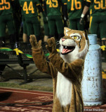 Bobcats mascot, with teammates and propane tank (for heater) in the background