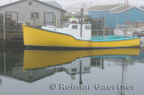Yellow lobster boat in fog at Fishermans Cove Eastern Passage Halifax Nova Scotia