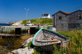 Working fishermen on the dock at Peggys Cove Nova Scotia with abandoned boat