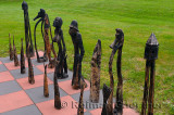 Set of large scale black chess pieces and board on an outdoor lawn