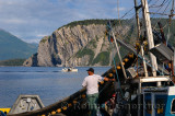Fishermen hauling in net on East Arm Bonne Bay at Norris Point at the end of the day with Shag Cliff